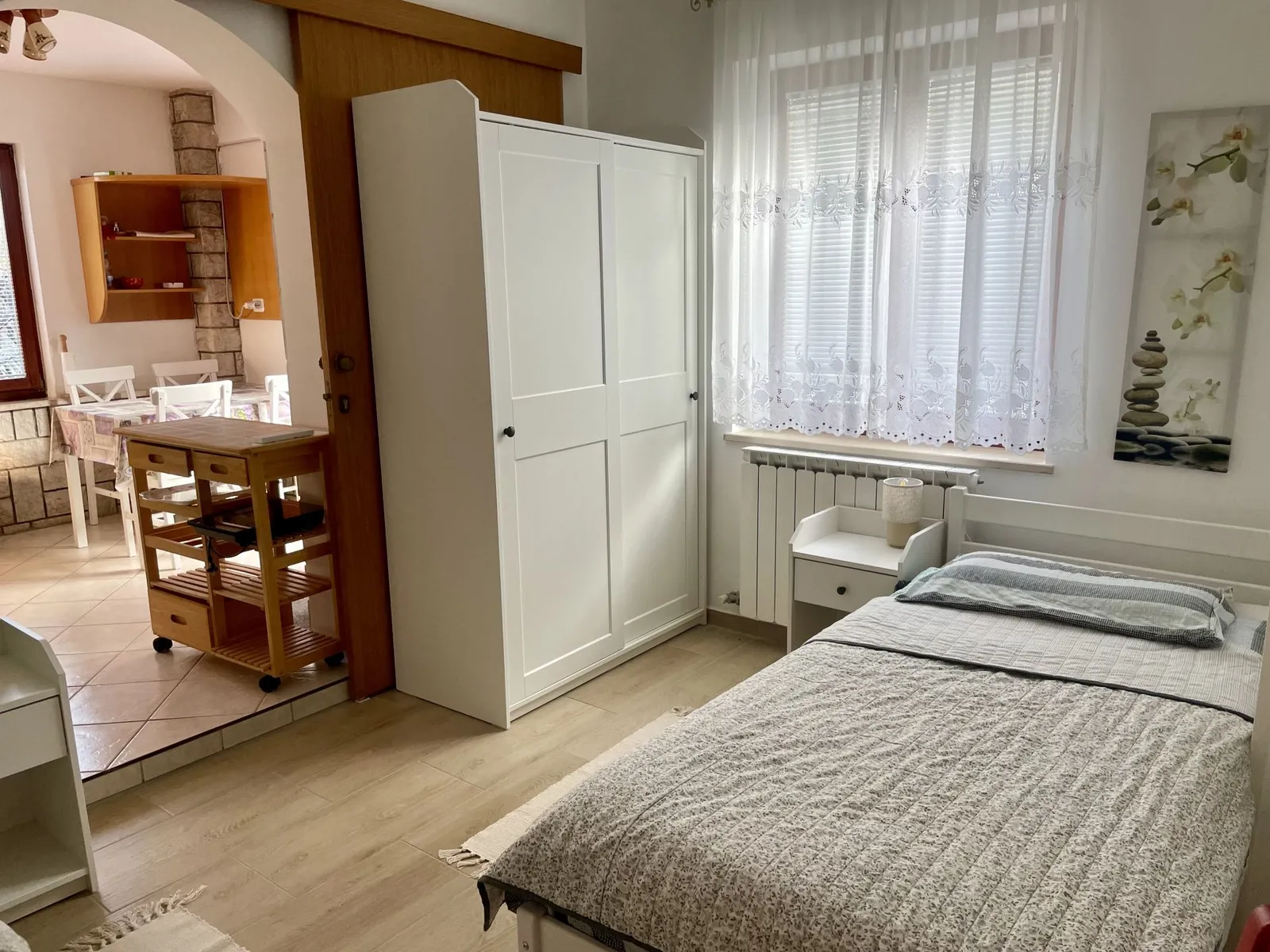 Soba z enojno posteljo in pogledom v kuhinjo