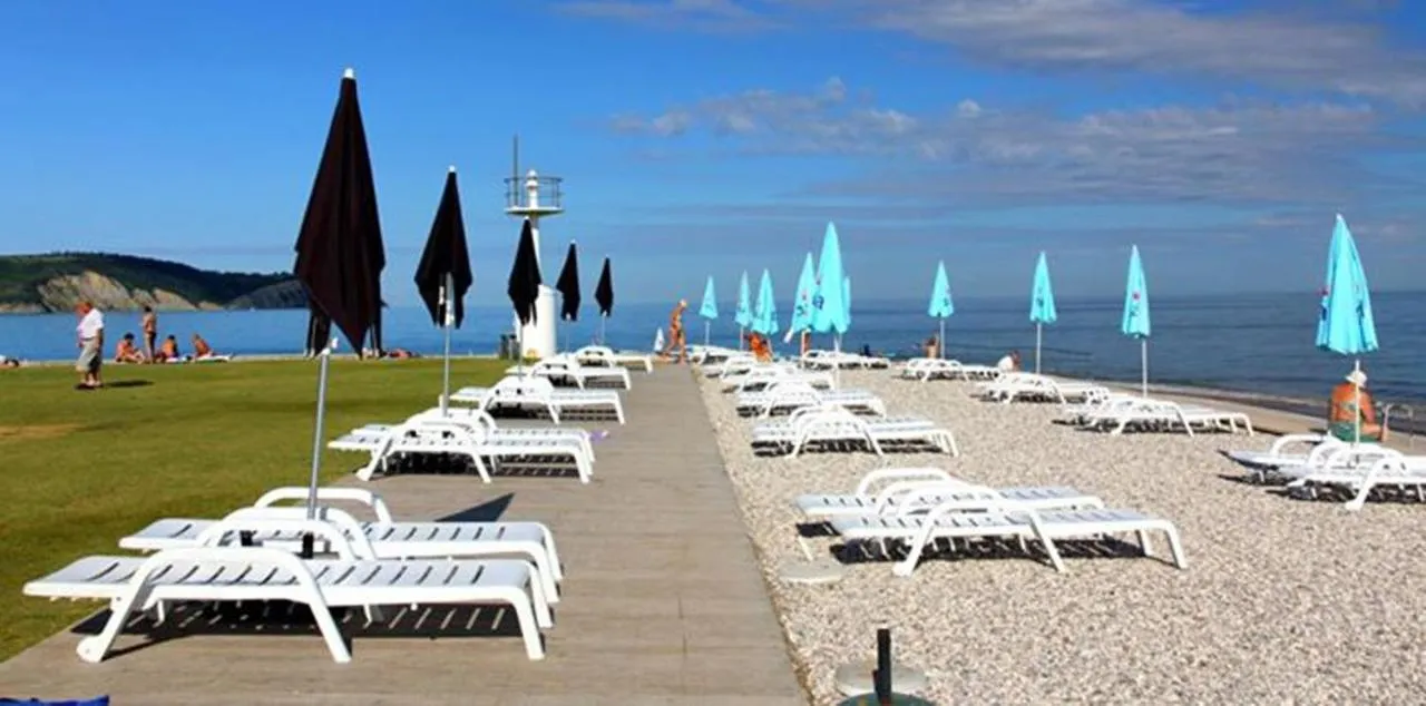 Ležalniki in senčniki na plaži Svetilnik, v ozadju svetilnik