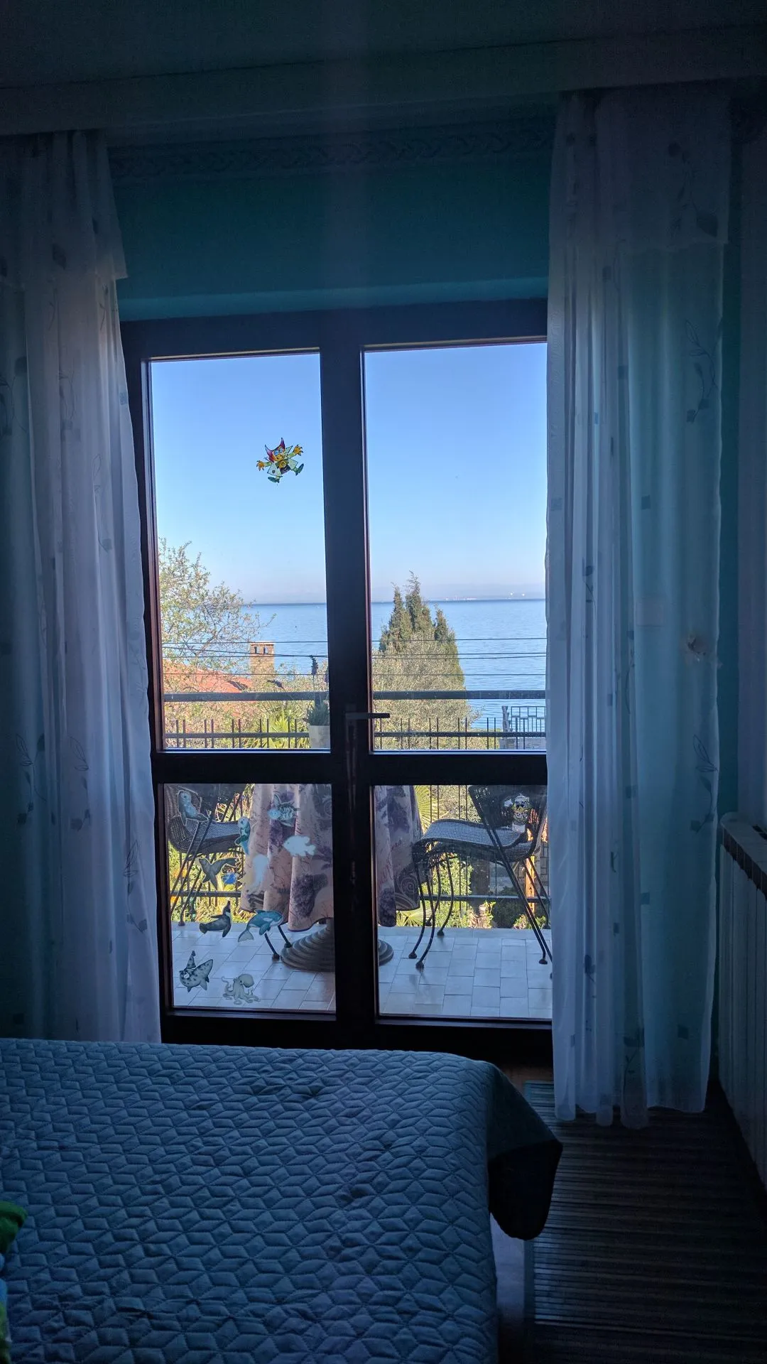 Okno spalnice s pogledom na balkon in morje